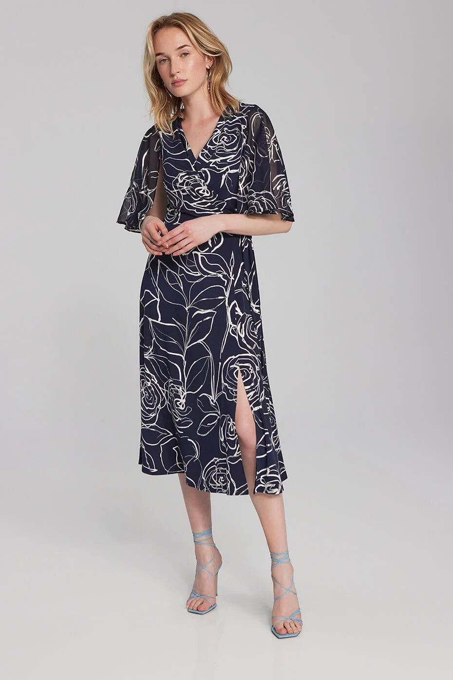 <p>Joseph Ribkoff Wrap style midi dress with chiffon sleeves and small slit at front in navy with a white floral pattern print</p>