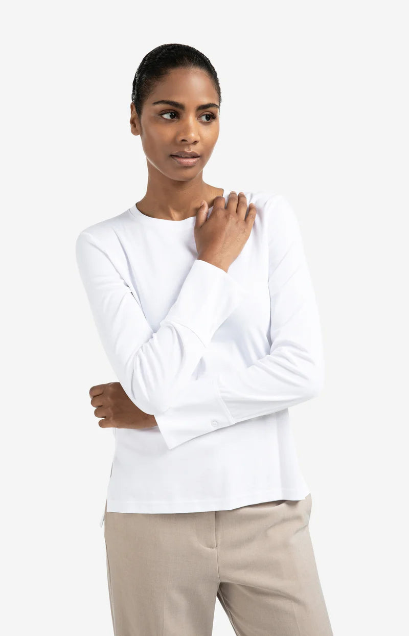 Woman wearing a white long-sleeve top and beige pants on a white background (front) 